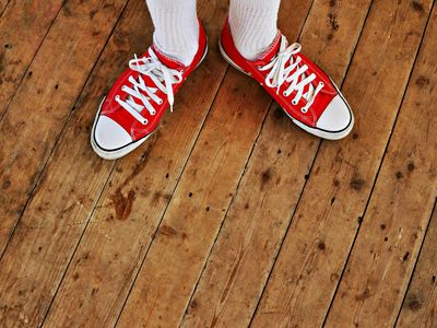 Pair of modern athletic shoes on a wooden floor.