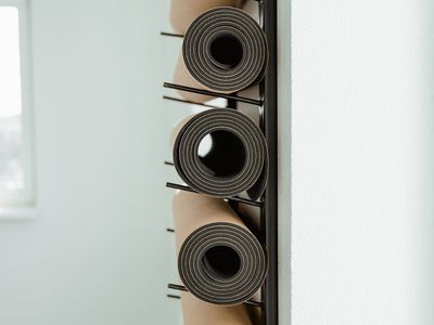 Rolled blue yoga mat in a sunny studio corner.